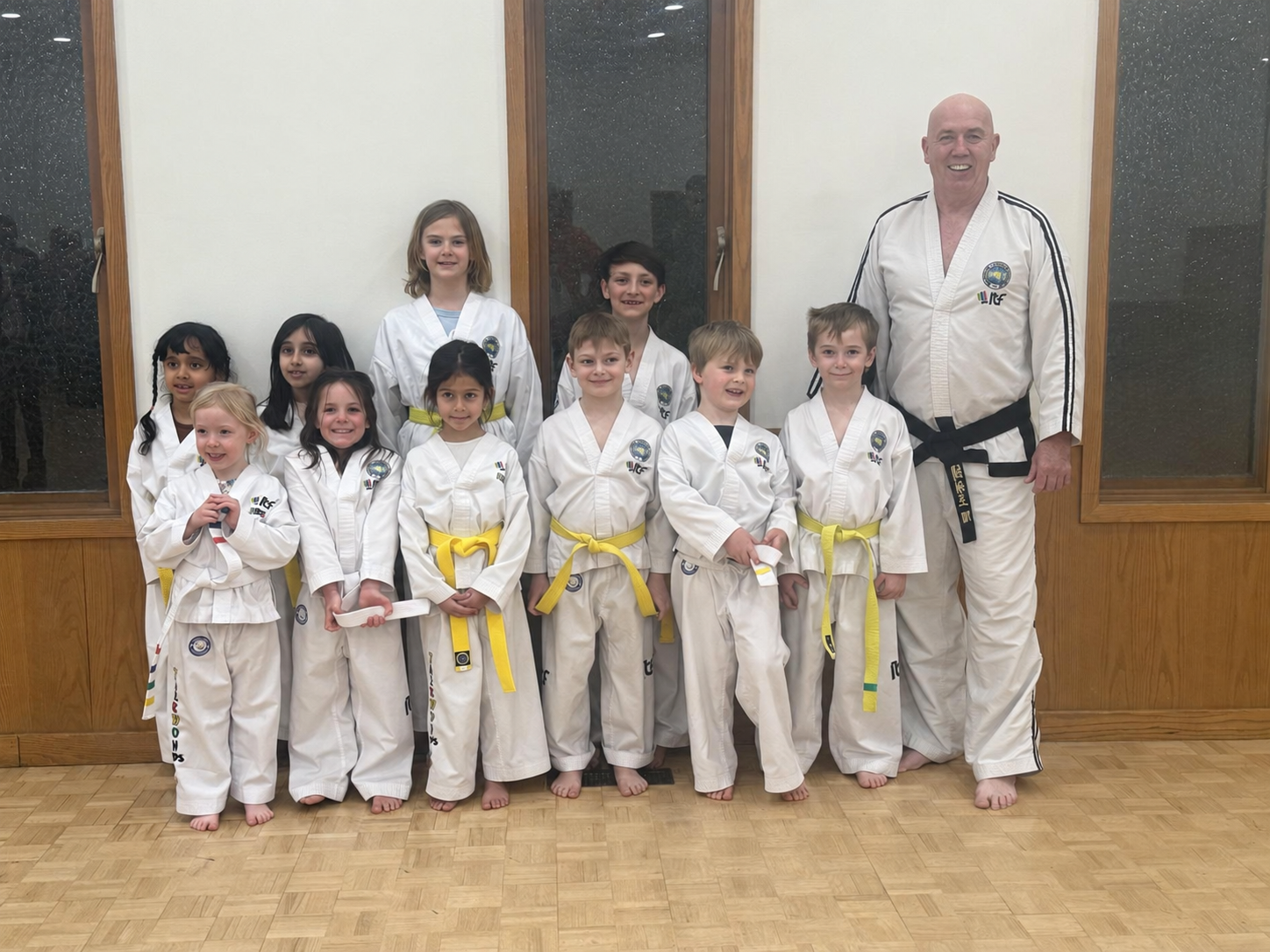 Master Barker with young Impact students in their white Taekwon-Do uniforms